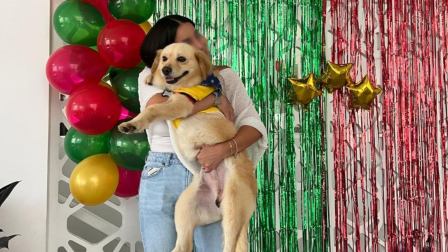 El perrito Messi es cargado por su nueva tutora, tras ser adoptado.