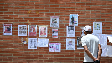 Un hombre observa fotografías de personas desaparecidas en Caraballeda, estado de La Guaira, Venezuela