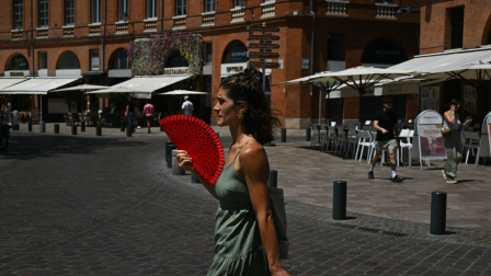 Una mujer se refresca con un abanico durante una ola de calor en Francia.