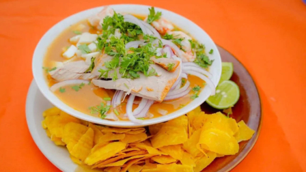 Imagen referencial de un plato de encebollado con chifles.
