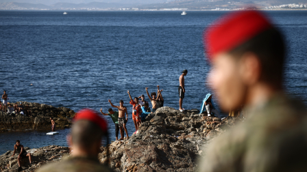 Miembros del Ejército español observan a un grupo de migrantes cerca del puesto fronterizo del enclave español de Ceuta, el 2 de agosto de 2026.