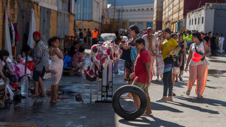 Migrantes esperan para recibir agua potable en e énclave español de Ceuta, en el norte de África.