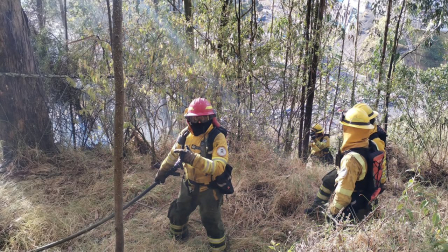 Miembros del Cuerpo de Bomberos Quito trabajan en el sector de El Trébol para controlar un incendio.
