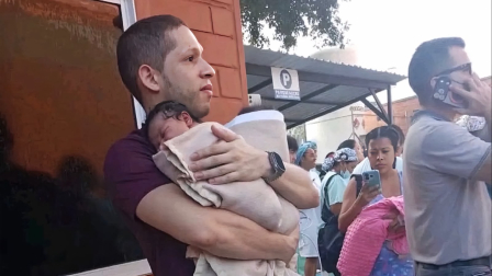 Germán Somoyar sostiene a los dos bebés que rescato durante el terremoto en Colombia.
