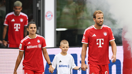 Entrenamiento del Bayern de Múnich - FC Bayern Campus, Múnich, Alemania - 17 de agosto de 2026. Harry Kane y Jovana Damnjanovic, del Bayern de Múnich, junto a una mascota antes del entrenamiento.
