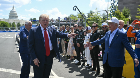 El presidente estadounidense Donald Trump hace un gesto a Roger Penske, presidente de Penske Corporation, a su llegada al Gran Premio Freedom 250 de IndyCar en Washington, D.C., el 23 de agosto de 2026. (Photo by SAUL LOEB / AFP)
