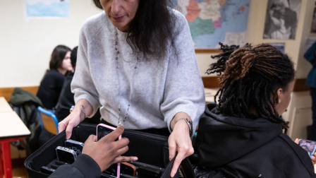 Una profesora recoge el teléfono móvil de un alumno, que este había dejado a un lado durante las clases en el instituto de formación profesional Jean Mermoz de Montsoult, en las afueras del norte de París.