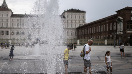 Varias personas se refrescan en una fuente pública en la Piazza Castello durante una ola de calor en Turín, el 3 de agosto de 2026.