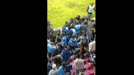 Hinchas de Macará frente a miembros de la Policía Nacional en el estadio de Independiente del Valle.