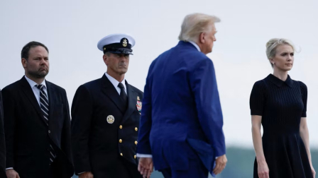 El presidente de Estados Unidos, Donald Trump, camina frente a Natalie Harp, asistente ejecutiva.