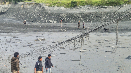Los lugareños caminan entre el lodo a lo largo de las orillas del río Budhi Gandaki, un día después de la inundación