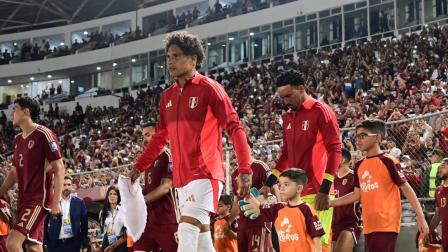 Paolo Guerrero (izq.) y Pedro Gallese saltan a la cancha del estadio Monumental de Lima, antes de un partido de las eliminatorias sudamericanas.