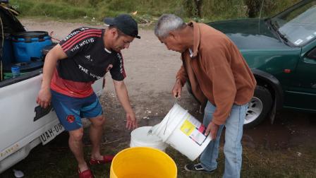 Moradores del barrio San Martin, uno de los sectores afectados en el sur de Quito por el desabastecimiento del líquido vital, buscan agua potable.