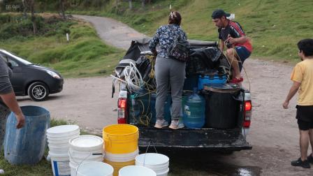 Moradores del barrio San Martin, uno de los sectores afectados en el sur de Quito por el desabastecimiento del líquido vital, consiguen agua para cubrir sus necesidades.