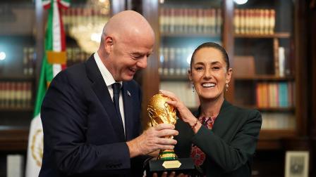 Claudia Sheinbaum (d), y el presidente de la Federación Internacional de Fútbol Asociado (FIFA), Gianni Infantino, sosteniendo una réplica del trofeo de la Copa del Mundo durante una reunión este jueves, en el Palacio Nacional de la Ciudad de México (México). Infantino entregó a Sheinbaum, un boleto simbólico para presenciar en primera fila el partido inaugural del Mundial 2026 en el Estadio Azteca, un gesto que confirma el papel protagónico del país como sede junto a Estados Unidos y Canadá.