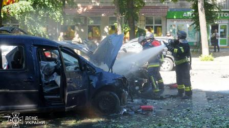 Rescatistas ucranianos extinguen un coche en llamas en el lugar de un ataque con misiles en Sumy, durante la invasión rusa de Ucrania.