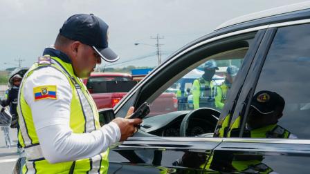 Agente de la Comisión de Tránsito del Ecuador (CTE) realiza un control de tránsito en vía.