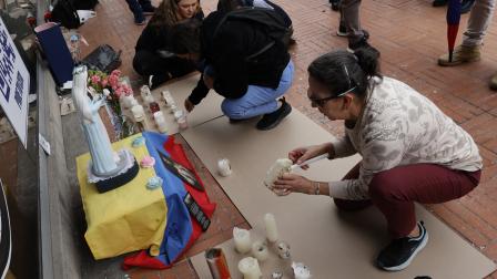 Personas ponen velas junto a la imagen de la Virgen para orar por la salud del precandidato presidencial colombiano, Miguel Uribe Turbay, este martes 10 de junio del 2025, en los exteriores del hospital donde está internado.