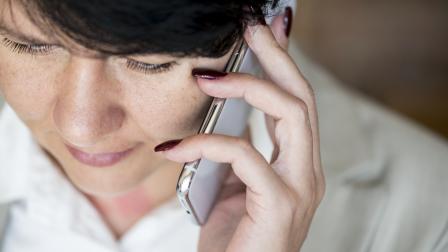 Mujer realizando una llamada telefónica por su celular.