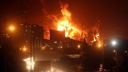 La gente conduce mientras el fuego y el humo se elevan desde el almacén de petróleo de Teherán en Teherán, Irán, el domingo15 de junio de 2024.
