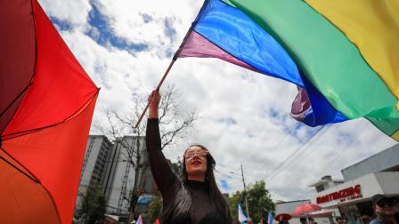 Una integrante de la comunidad LGBT+ ondea una bandera en la Marcha del Orgullo este sábado, en Quito