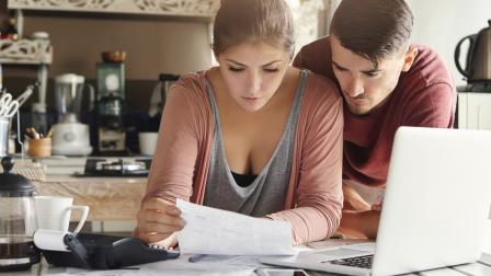 Una joven pareja revisa las cuentas en su casa.
