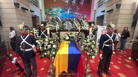 Miembros de la Guardia Presidencial junto al féretro y el retrato del candidato presidencial colombiano Miguel Uribe.