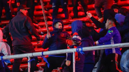 Hinchas de U de Chile se enfrentan en una tribuna el miércoles 20 de agosto, en un partido de los octavos de final de la Copa Sudamericana entre Independiente y Universidad de Chile en el estadio Libertadores de América en Avellaneda